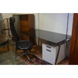 An Ikea black toughened glass rectangular adjustable office desk complete with two drawer soft