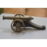 A treen gun carriage mounted with brass wheels and miniature canon (h. 8cm x l.25cm)