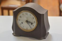 A 1930s Smiths Enfield brown bakelite chiming mantel clock with enamel dial, twin key apertures