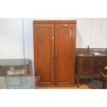 A Victorian mahogany wardrobe, the moulded cornice above a pair of arched inset panel doors,