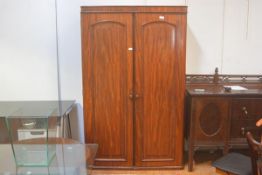 A Victorian mahogany wardrobe, the moulded cornice above a pair of arched inset panel doors,