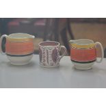 A Susie Cooper for Gray's Pottery handpainted pair of milk jugs with yellow, orange and black banded