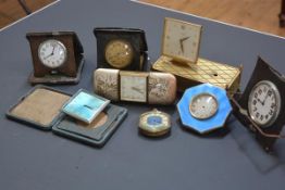 A group of seven vintage travel clocks, some with engine-turned enamel cases (losses); together with