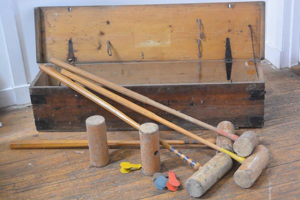 An early 20th century croquet set (incomplete), with four mallets, in its original pine box.