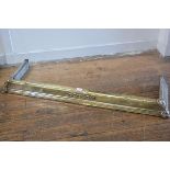 An Arts & Crafts silvered brass kerb style fender, with stylised knot design to front (inside