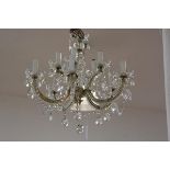 A George III style ten-light cut-glass chandelier, suspending prismatic drops, with brass rose and