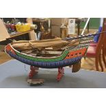 A painted wooden model of a Chinese junk, brightly decorated with tiller, masts anchor etc (losses).