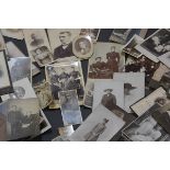 A group of unframed early 20th century sepia and black and white portrait photographs.