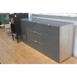 A modern grey toughened glass topped and fronted oak veneered side cabinet fitted with a central
