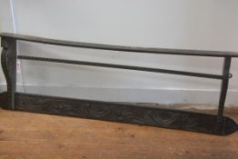 A late Victorian carved oak wall rack, in relief with a band of scrolling acanthus. 43cm by 138cm