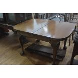 A George III style mahogany drawleaf dining table, early 20th century, the rectagular top with bowed