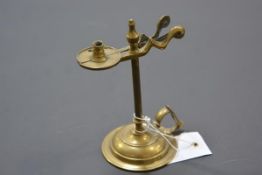A 19th century brass taper holder/snuffer, with urn finial, on a circular base. 14cm