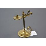 A 19th century brass taper holder/snuffer, with urn finial, on a circular base. 14cm