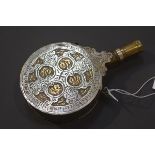 A late 19th century white metal and brass powder flask, probably Turkish, circular, with engraved