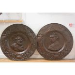 A pair of unusually large commemorative patinated metal roundels, one in relief with an image of