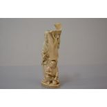 A Japanese carved ivory okimono, c. 1900, worked as a father and son, each holding a brush, the