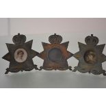 Three World War I trench art metal photograph frames, each modelled as a star badge surmounted by