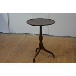 A George III mahogany tripod table, the circular dish top on a turned baluster standard over