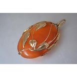 A 14ct gold-mounted agate pendant in the Art Nouveau taste, the oval stone within a foliate modelled