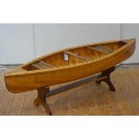 A large child's or model canoe, hand-built, with associated paddle and with customised stand. Length