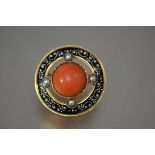 A coral and seed pearl enamel and gold brooch, of circular form, centred by a coral cabochon, with