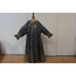 A Chinese silk surcoat, 20th century, worked in gilt threads against a blue ground with dragons,