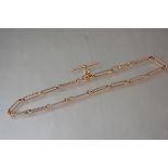 A late Victorian 9ct gold watch chain, of elongated oval links, with lobster clasp and t-bar. Length