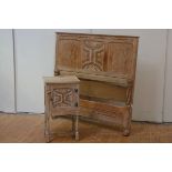 A limed oak bedside cupboard, c. 1920, the rectangular top over a panelled door, with relief-