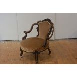 A mid-19th century carved walnut drawing room chair, the S-scroll outswept arms and back enclosing