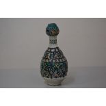 A Persian pottery bottle vase of garlic head shape, decorated in a palette of blues and greens in