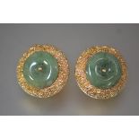 A pair of jade-mounted 18ct gold earrings, each with a jade disc mounted on a textured plaque,