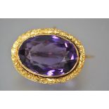 An amethyst brooch, the large oval-cut stone mounted in (unmarked) yellow metal, with floral