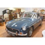 A 1970 MG B Roadster, with hard top and soft top, chrome wire wheels, in blue with black interior,