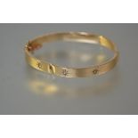 A diamond-set 9ct gold bangle, the hollow bangle (dented), set with three old-cut diamonds (a/f).