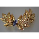 A sapphire-set 18ct gold spray brooch, the foliate spray centred by eight sapphire points, stamped