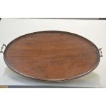 An Edwardian mahogany tea tray in Georgian style, oval, galleried, with twin brass handles. Width