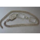 A 19th century silver folding lorgnette, unmarked, in a scroll-engraved case, on a white metal (