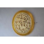 A large Canton yellow metal mounted ivory brooch, c. 1900, the oval domed plaque elaborately