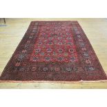 A Mashad hall carpet, the central panel with fourteen rows of stylised flowerheads enclosed within a