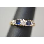 A five stone diamond and sapphire ring, the pair of round-cut sapphires flanked and divided by round