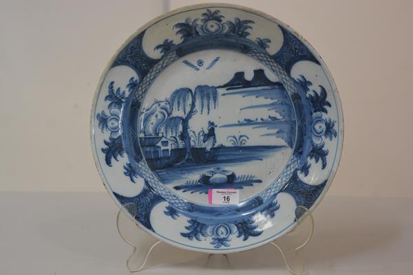 An 18th century Delft blue and white charger, c. 1750, the well painted with a figure under a willow