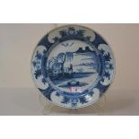 An 18th century Delft blue and white charger, c. 1750, the well painted with a figure under a willow