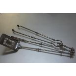 A set of Regency steel fire irons, c. 1820, compsiring shovel, tongs and poker, each with knop-