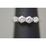 A four stone diamond ring, the graduated round brilliant-cut stones claw set in platinum, on an 18ct