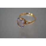 An 18ct gold single stone amethyst ring, the cushion-cut stone claw-set between split shoulders,