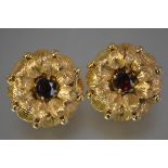A pair of 9ct gold ruby-set earrings, each modelled as a flowerhead centred by a round-cut ruby,