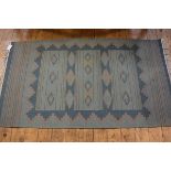 A kelim rug, the centre panel with three bars, with stylised floral and leaf motifs, green ground (