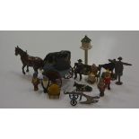 A group of 1920's die-cast figures inc. lady and gentleman on a bench, four gnomes, a cart,