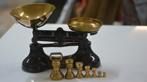 A set of Scotts of Stow black enamelled kitchen scales,with a set of seven weights. 20cm