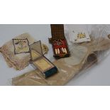 A pair of lady's Le Gant Tre Fusse kidskin gloves, a group of lace handkerchiefs, a mini vanity case